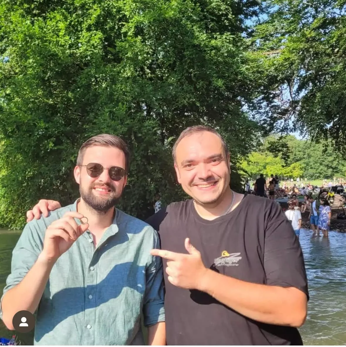 Ringjäger und Kunde an einer belebten Badestelle, im Hintergrund viele Menschen
