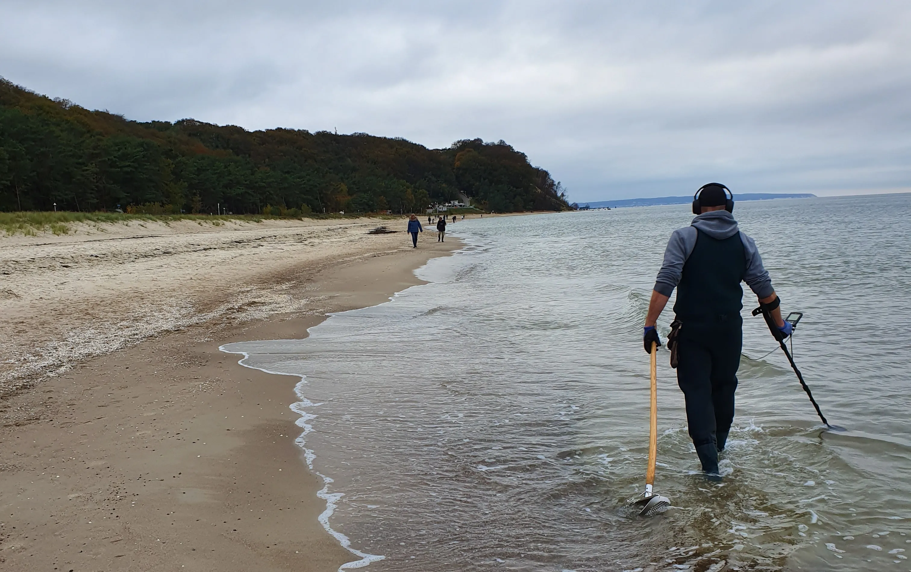 Auftragssucher mit Metalldetektor am Strand